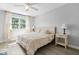 Comfortable bedroom with neutral walls, hardwood floors, ceiling fan, and a large window at 6133 Buttonwood Dr, Noblesville, IN 46062