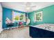 Bright bedroom with blue walls, two windows, a ceiling fan, and hammock chair at 6133 Buttonwood Dr, Noblesville, IN 46062