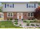 Close up of the home's welcoming front entrance with red brick, vinyl siding, and well-maintained landscaping at 6133 Buttonwood Dr, Noblesville, IN 46062