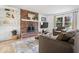Inviting living room features a brick fireplace, comfortable seating, bright window, and wood-look floors at 6133 Buttonwood Dr, Noblesville, IN 46062