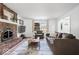 Well-lit living room features a brick fireplace, comfortable seating, large window, and wood-look floors at 6133 Buttonwood Dr, Noblesville, IN 46062