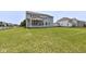 Expansive, well-manicured backyard with lush green grass, black aluminum fence, and covered patio at 6160 Hardwick Dr, Whitestown, IN 46075