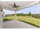 Covered patio with a ceiling fan overlooks a large, well-maintained backyard and distant trees at 6160 Hardwick Dr, Whitestown, IN 46075