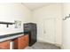 Garage interior with a refrigerator, storage cabinets, counter space, and a door leading to the outside at 6160 Hardwick Dr, Whitestown, IN 46075