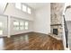 Bright living room with a floor-to-ceiling stone fireplace, large windows, and beautiful hardwood floors at 6160 Hardwick Dr, Whitestown, IN 46075
