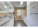 Well-lit kitchen featuring white cabinets, laminate counters, and necessary appliances, offering practicality and storage at 6514 Jackson St, Indianapolis, IN 46241