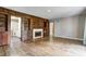Open living room featuring hardwood floors, a fireplace, and access to other rooms at 6514 Jackson St, Indianapolis, IN 46241