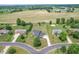 Aerial view of a well-maintained neighborhood showcasing homes with large yards and farmland in the distance at 6702 W Willow Grove Dr, New Palestine, IN 46163