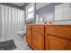 Bathroom with wooden vanity, gray walls, and a white shower curtain at 6702 W Willow Grove Dr, New Palestine, IN 46163