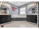 Bathroom featuring double sinks, large mirrors, a large window, and a corner soaking tub at 6702 W Willow Grove Dr, New Palestine, IN 46163