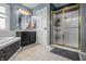 Updated bathroom with glass shower, soaking tub, vanity, and attractive light fixture at 6702 W Willow Grove Dr, New Palestine, IN 46163