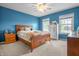Bedroom with blue walls, carpet, a wooden bed frame, and a ceiling fan at 6702 W Willow Grove Dr, New Palestine, IN 46163