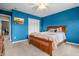 Bedroom with blue walls, a wooden bed, ceiling fan, and carpet flooring at 6702 W Willow Grove Dr, New Palestine, IN 46163