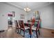 Dining room with table, hardwood floors, chandelier, and lots of natural light, ideal for entertaining at 6702 W Willow Grove Dr, New Palestine, IN 46163