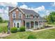 Beautiful two-story brick home with landscaped yard, inviting front porch, and classic architectural details at 6702 W Willow Grove Dr, New Palestine, IN 46163