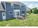 Back view of home featuring an outdoor patio, grill, and manicured lawn at 6702 W Willow Grove Dr, New Palestine, IN 46163