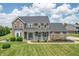 Charming brick home featuring a cozy front porch, lush lawn, and manicured landscaping at 6702 W Willow Grove Dr, New Palestine, IN 46163