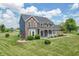 Lovely brick home with a manicured lawn, a welcoming front porch and mature trees in the background at 6702 W Willow Grove Dr, New Palestine, IN 46163