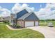 Brick two-story home with a manicured lawn, three car garage, and a charming front porch at 6702 W Willow Grove Dr, New Palestine, IN 46163
