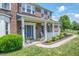 Inviting front porch with rocking chair, colorful flowers, and manicured shrubs enhance this lovely brick home at 6702 W Willow Grove Dr, New Palestine, IN 46163