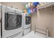 Laundry room featuring a washer, dryer, shelving, and white tile flooring at 6702 W Willow Grove Dr, New Palestine, IN 46163