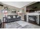 Comfortable living room featuring a gray sofa, tiled fireplace, large television, and decorative accents for a cozy feel at 6702 W Willow Grove Dr, New Palestine, IN 46163