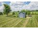 Backyard shed with white trim, garden, and trailer in the manicured lawn at 6702 W Willow Grove Dr, New Palestine, IN 46163