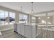 Stylish kitchen island featuring a stainless steel sink, quartz countertops, and modern pendant lighting at 6770 W Buck Stone Dr, McCordsville, IN 46055