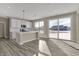Open-concept kitchen with stainless steel appliances, white cabinetry, and a sliding glass door to the backyard at 6770 W Buck Stone Dr, McCordsville, IN 46055