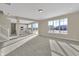 Spacious living room featuring abundant natural light, plush carpeting, and a seamless flow to the modern kitchen at 6770 W Buck Stone Dr, McCordsville, IN 46055
