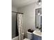 Bathroom features a modern vanity, patterned shower curtain, and contemporary lighting fixture at 711 E 16Th St, Indianapolis, IN 46202