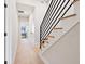 Hallway featuring a carpeted floor, black railings, and access to multiple rooms at 711 E 16Th St, Indianapolis, IN 46202
