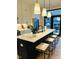 Kitchen island with a white countertop, dark cabinets, seating and pendants, with a view to the backyard at 711 E 16Th St, Indianapolis, IN 46202