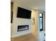Living room with a sleek fireplace, TV, and modern design elements with natural lighting at 711 E 16Th St, Indianapolis, IN 46202
