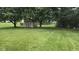 Lush backyard featuring a storage shed, mature trees, and a spacious lawn area at 7168 Camwell Dr, Indianapolis, IN 46268