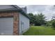 Side view of the home showcasing light blue siding, a brick facade, and a well-maintained grassy lawn at 7168 Camwell Dr, Indianapolis, IN 46268