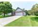Well-maintained home with a two-car garage, a lush green lawn, and mature trees at 7168 Camwell Dr, Indianapolis, IN 46268