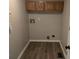 Functional laundry room with wood cabinets and hookups, providing a practical space for household chores at 7168 Camwell Dr, Indianapolis, IN 46268
