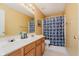 Well-lit bathroom with double vanity, decorative shower curtain, and yellow walls at 7193 Wythe Dr, Noblesville, IN 46062