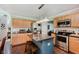 Well-lit kitchen with wood cabinets, stainless appliances, and an island with seating, perfect for casual dining and food preparation at 7193 Wythe Dr, Noblesville, IN 46062