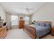 Calm main bedroom with neutral walls, a ceiling fan, two windows, and wooden furniture including a bed and dressers at 7193 Wythe Dr, Noblesville, IN 46062