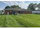 Backyard view of brick home, open patio, and well-manicured lawn at 7346 E Buddy Ln, Camby, IN 46113