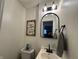 Bathroom featuring modern fixtures, including a round mirror, stylish vanity, and modern lighting at 7346 E Buddy Ln, Camby, IN 46113