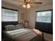 Cozy bedroom with a patterned quilt, ceiling fan, and soft natural light streaming through the windows at 7346 E Buddy Ln, Camby, IN 46113