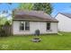 The backyard features a stone firepit, green lawn, air conditioning condenser, and partial fence at 7743 Waterwood Dr, Indianapolis, IN 46214