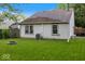 The backyard features a stone firepit, green lawn, air conditioning condenser, and partial fence at 7743 Waterwood Dr, Indianapolis, IN 46214