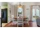 Cozy dining area with a chandelier, white chairs, and natural light from a window at 7743 Waterwood Dr, Indianapolis, IN 46214