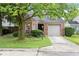 Charming brick home featuring an attached garage, mature trees, and a well-maintained front yard at 7743 Waterwood Dr, Indianapolis, IN 46214