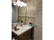 A floral wallpapered bathroom featuring a single sink vanity with wooden cabinets and light fixtures at 7950 Eagle Valley Pass, Indianapolis, IN 46214