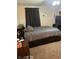 This is a cozy bedroom that features a queen bed with dark curtains and modern furniture at 7950 Eagle Valley Pass, Indianapolis, IN 46214